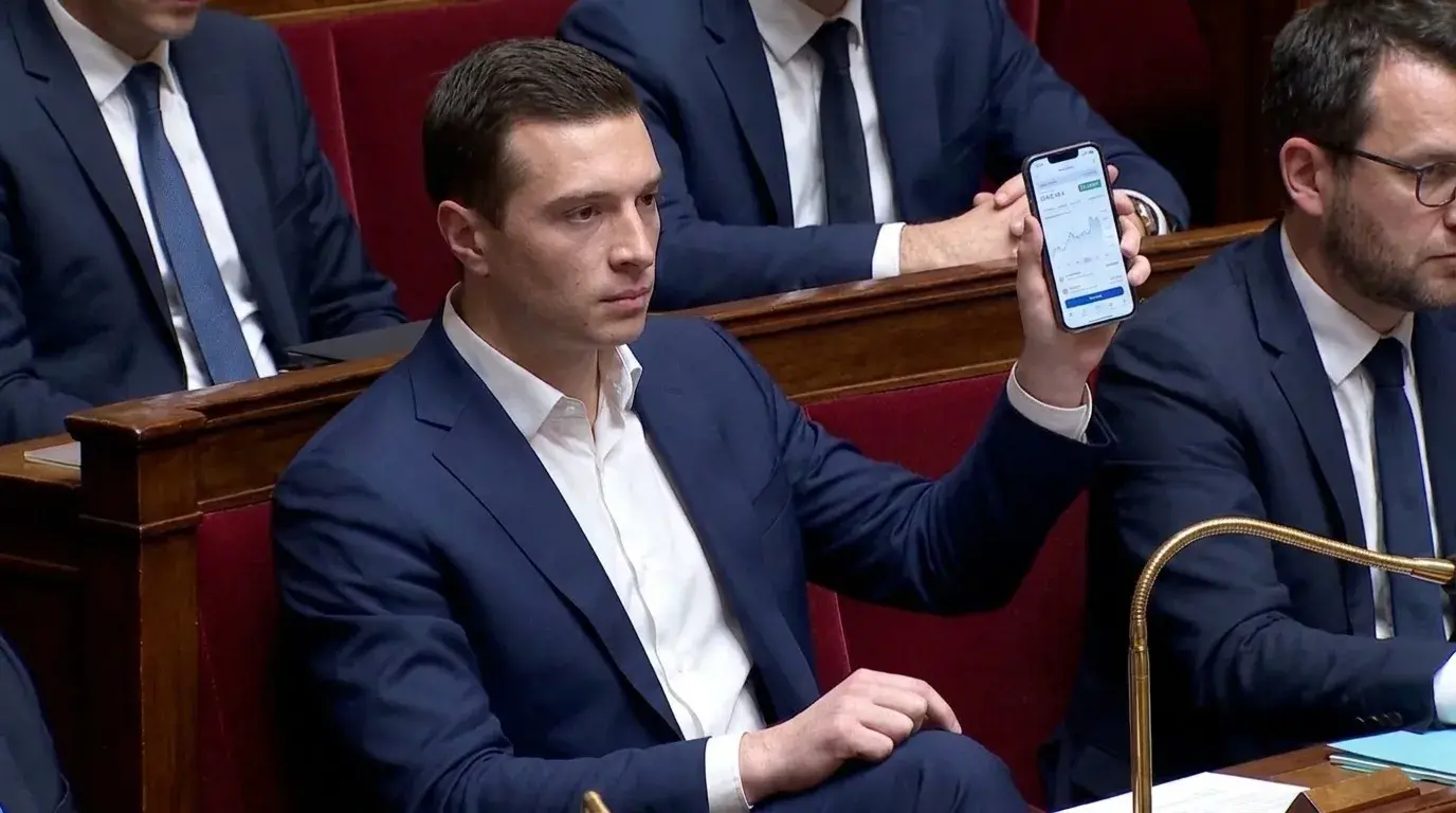 Bardella brandit son téléphone, montrant l'interface de la plateforme.